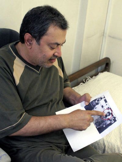 Former Iranian secret agent Saeed Hajjarian points to a copy of a photograph showing a U.S. hostage and an Iranian during the 1979 seizure of the U.S. Embassy in Tehran.
(Associated Press / The Spokesman-Review)