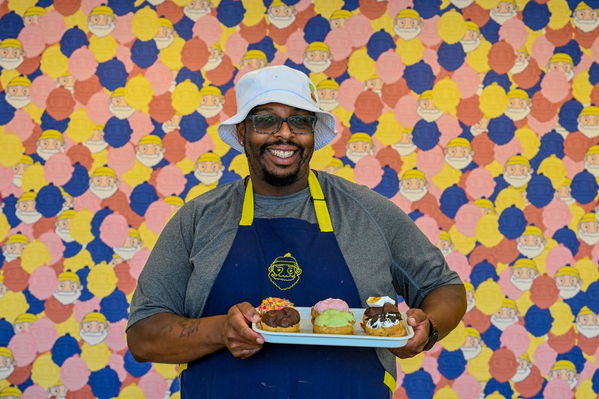 Marc Bryant, owner of Beard Papa’s bakery displays a tray of cream puffs at the Spokane Valley location on Thursday. He co-owns the bakery with his wife, Sawako Hiraoka.  (Kathy Plonka/The Spokesman-Review)