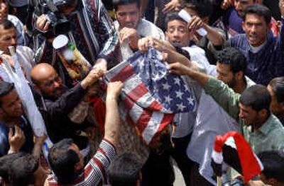 
Iraqi demonstrators set fire to an American flag.
 (Associated Press / The Spokesman-Review)