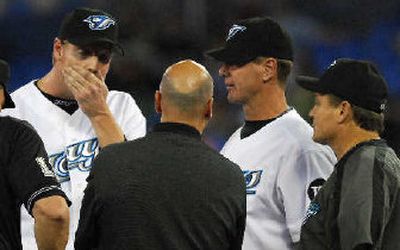 
 Roy Halladay, left, huddles with coaches before leaving his last start on Wednesday. 
 (Associated Press / The Spokesman-Review)