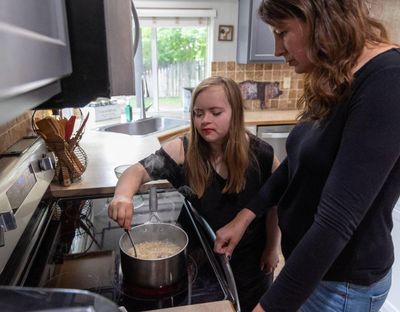 Shannon French helps her daughter, Ruby, make lunch. Under the oversight of Idaho’s Department of Health and Welfare, Medicaid has paid for French to care for Ruby, who has Down  (Darin Oswald)