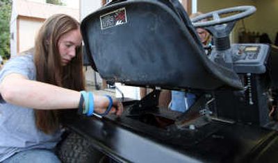 
Kymberly Bowlby, a Coeur d'Alene Charter Academy student, tightens a bolt on a lawn mower that will be entered in the Big Back-In lawn mower drag races.
 (Photo by Taryn Hecker / The Spokesman-Review)