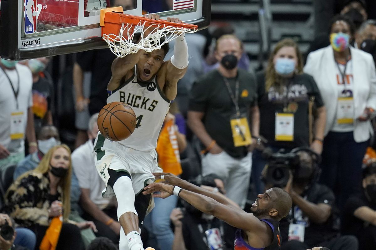 Milwaukee Bucks forward Giannis Antetokounmpo, top, dunks over Phoenix Suns guard Chris Paul during the second half of Game 5 of basketball’s NBA Finals, Saturday, July 17, 2021, in Phoenix.  (Ross D. Franklin)