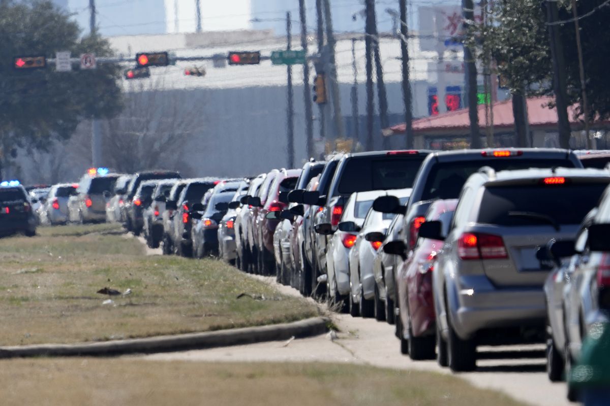 Car are lined up outside at a City of Houston water distribution site Friday, Feb. 19, 2021, in Houston. The drive-thru stadium location was setup to provide bottled water to individuals who need water while the city remains on a boil water notice or because they lack water at home due to frozen or broken pipes.  (David J. Phillip/Associated Press)