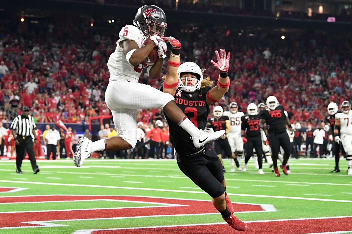 Washington State Cougars wide receiver Travell Harris (5) brings down a touchdown pass against Houston Cougars safety Grant Stuard (3) during the second half of a college football game on Friday, September 13, 2019, at NRG Stadium in Houston, Texas. (Tyler Tjomsland / The Spokesman-Review)