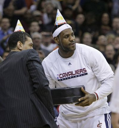 Cleveland’s LeBron James, right, poses for a photo with a birthday cake before the Cavaliers beat the Atlanta Hawks. (Associated Press)