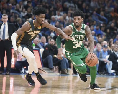 Boston Celtics guard Marcus Smart drives past Oklahoma City Thunder guard Shai Gilgeous-Alexander during the second half on Sunday in Oklahoma City. (Kyle Phillips / AP)