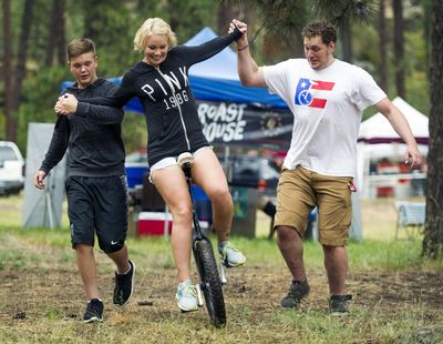 Melissa Wheeler, with the help of her son Daetyn Wheeler, 13, left, and Phil Sanders, on right, learns to ride a unicycle at Spokatopia Outdoor Adventure Festival. The annual festival is Saturday. (Colin Mulvany / The Spokesman-Review)