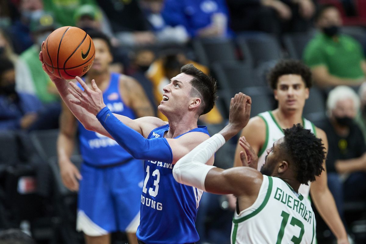 BYU guard Alex Barcello, left, shoots next to Oregon forward Quincy Guerrier during the second half of an NCAA college basketball game in Portland, Ore., Tuesday, Nov. 16, 2021.  (Associated Press)