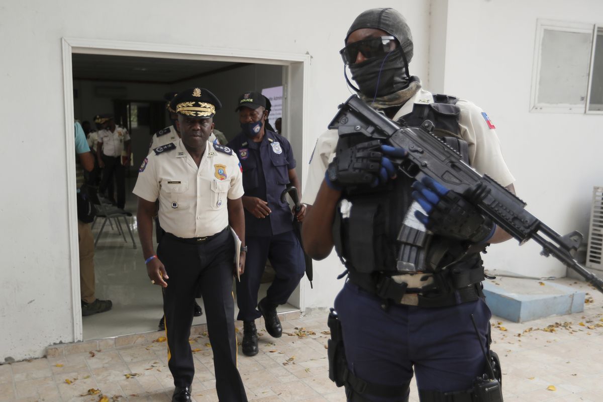 Leon Charles, left, Director General of Haiti’s Police leaves a room after a news conference at police headquarters in Port-au-Prince on Wednesday. Charles gave an updated on the investigation of the July 7 assassination of President Jovenel Moise.  (Associated Press)
