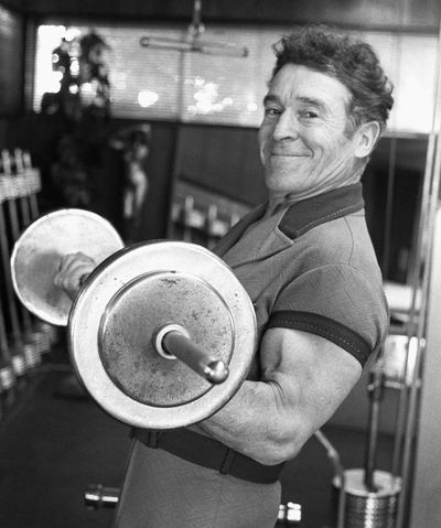 In this 1980  photo, Jack LaLanne pumps iron in the gym in his home in Hollywood.  (Associated Press)