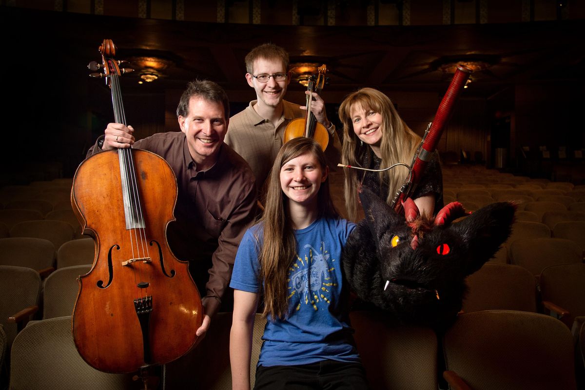 Three members of the Marshall family play for the Spokane Symphony. John Marshall plays the cello; James Marshall plays the viola; 
Lynne Feller-Marshall plays the bassoon. Jeanne Marshall, a puppet designer, holds Garth, the dragon puppet she created. (Colin Mulvany / The Spokesman-Review)