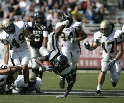
Nevada's Robert Hubbard dives between UI's Tone Taupule (16), D.J. Dykes (49), Ryan Davis (94) and Cole Snyder (47). 
 (Associated Press / The Spokesman-Review)