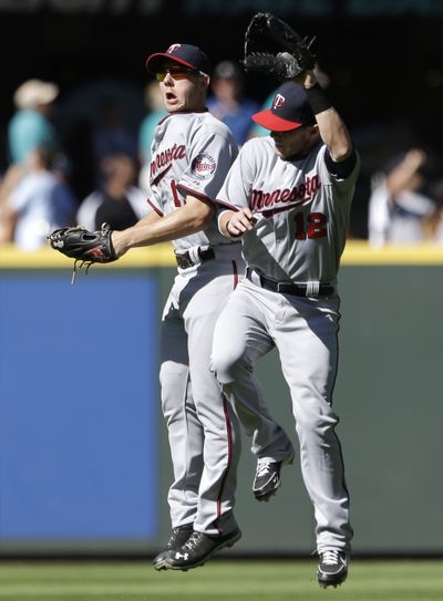 Clete Thomas, left, and Chris Herrmann celebrate after the Twins’ win Saturday. (Associated Press)