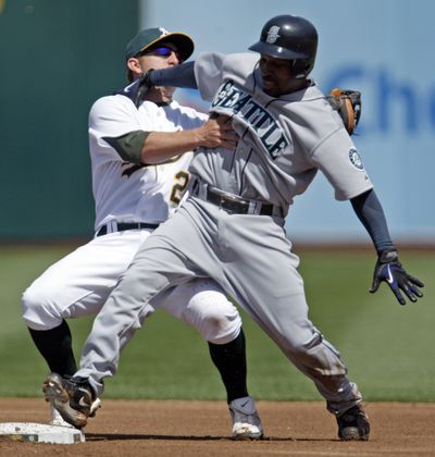 Cliff Pennington tags out Seattle’s Chone Figgins during an attempted steal at second.  (Associated Press)