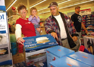 
Tammy Farmer, left, her daughter Abie and husband Archie look over a crock pot on sale at Sears in Paris, Texas. Sears is among many retailers that are tightening rules on gift returns.
 (Assocaited Press / The Spokesman-Review)