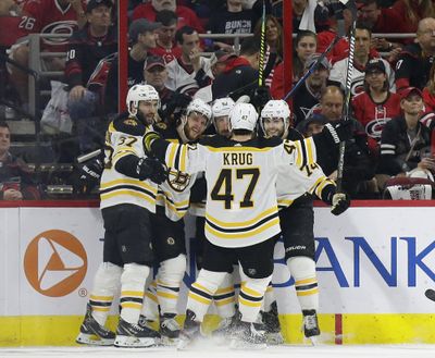 Boston Bruins’ Patrice Bergeron (37) David Pastrnak, second from left, Brad Marchand (63), Jake DeBrusk (74) and Torey Krug (47) celebrate Pastrnak’s goal against the Carolina Hurricanes during the second period in Game 4 of the NHL hockey Stanley Cup Eastern Conference finals in Raleigh, N.C., Thursday, May 16, 2019. (Gerry Broome / Associated Press)