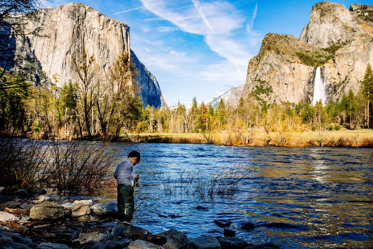 At the water’s edge, Ruga Lee, 4, of Tallahassee, Florida, holds his new stuffed animal – squirrel as his parents stand near by taking his photograph next to the rising Merced River on April 26, 2023, inside Yosemite National Park in California. Hundreds of National Park Service employees have opted to take the Trump administration’s buyout offer, adding to the operational concerns facing parks including Yosemite. (Francine Orr)