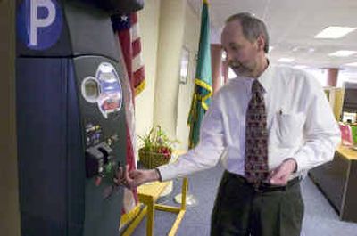 
Dave Mandyke demonstrates a parking station the city will test downtown. Users  can pay for parking with change, credit or debit cards. 
 (Colin Mulvany / The Spokesman-Review)