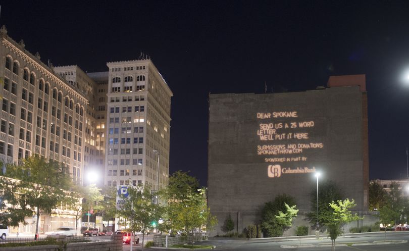 A projection on the Columbia Bank Building asks for submissions to Spokane Throw, an art project that will project letters from Spokane residents onto the blank sides of buildings. (Jesse Tinsley)