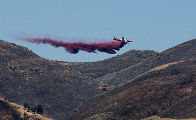 
A tanker drops fire retardant on the north side of Peavine Peak where the Verdi fire continued to burn Saturday near Reno, Nev. The fire narrowly missed a subdivision in the Sierra foothills. 
 (Associated Press / The Spokesman-Review)