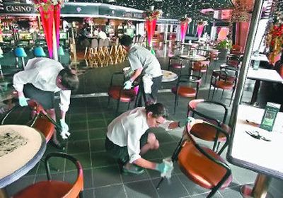 
Carnival Corp. employees use a chlorine bleach solution to sanitize chairs and tables on the Fascination's Promenade deck. 
 (Associated Press / The Spokesman-Review)