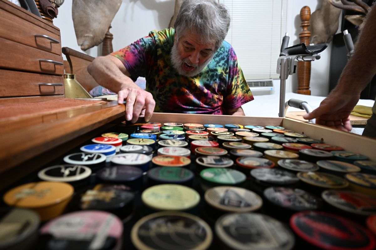 John Newbury, who lives in Chewelah, Washington, looks over a drawer in a cabinet that displays his extensive collection of typewriter ribbon tins, which were how typewriter ribbons were packaged for office workers. After a lifetime of hunting and fishing hobbies, Newbury has been slowed by a neuromuscular disease and has spent the last several years gathering his typewriter ribbon tin collection, amassing more than 1500.  (Jesse Tinsley/The Spokesman-Review)