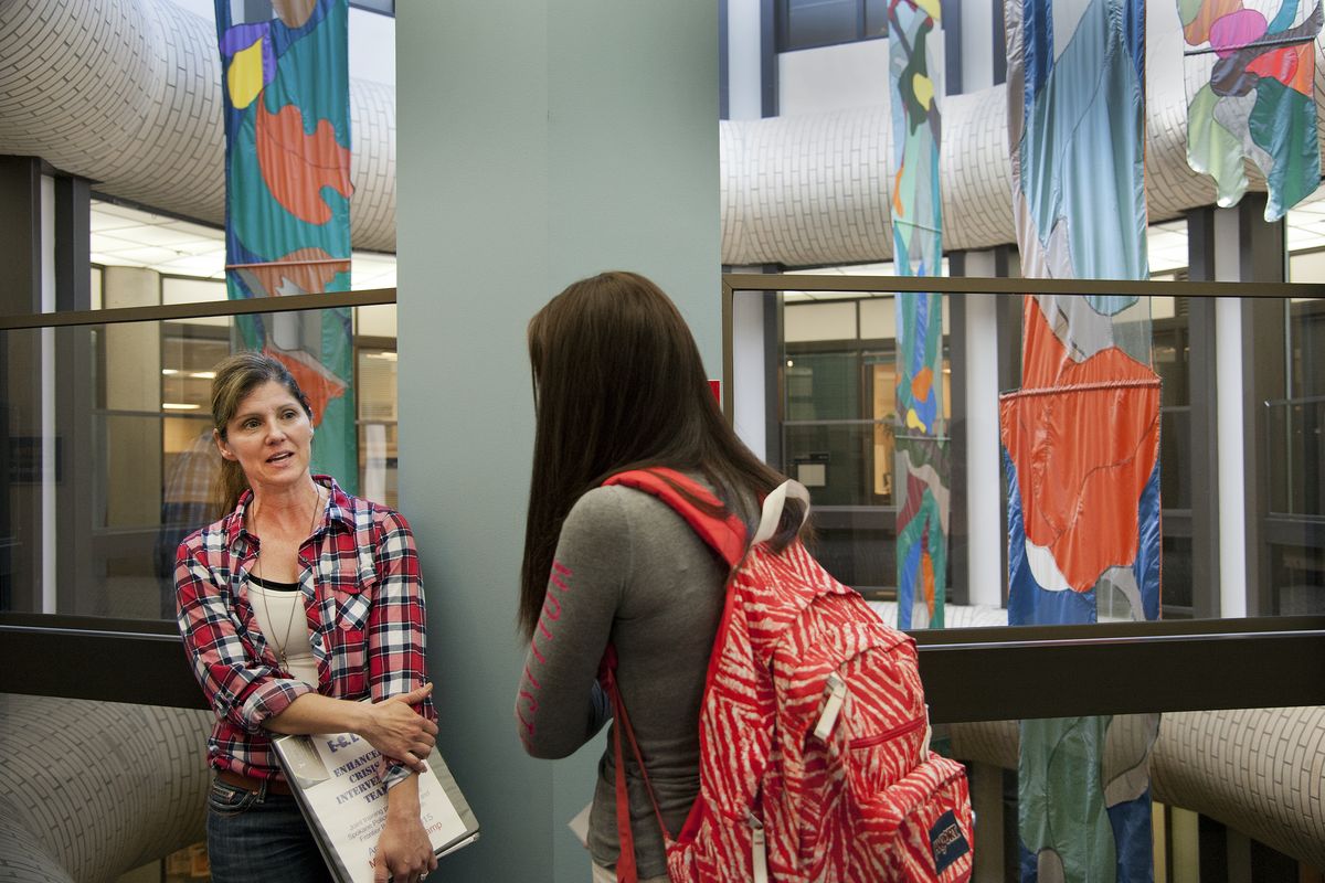 Spokane police Officer Michele Kernkamp, left, talks with Jen Wagner in the Spokane Regional Health District building after a crisis intervention training session at the county’s methadone clinic in April. (Dan Pelle)