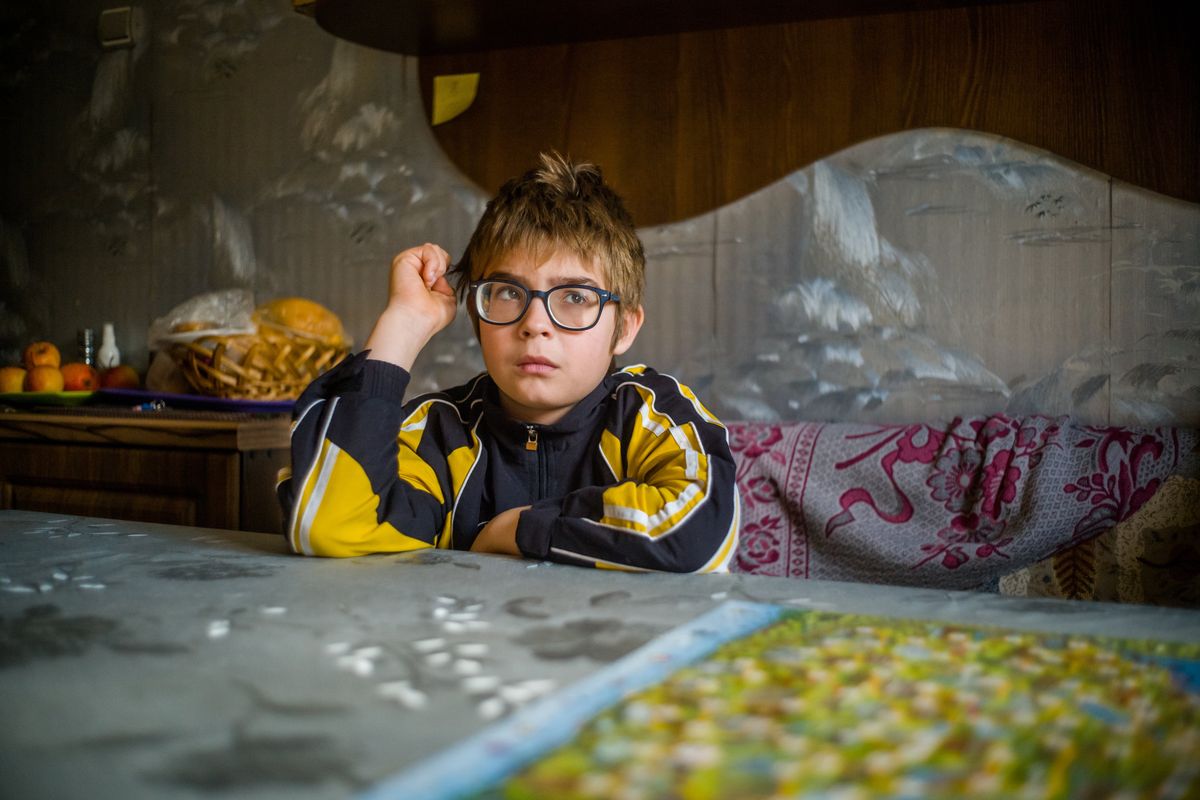 Misha, who lives in an orphanage near Kherson, sits at a table in an apartment in Stepanivka, Ukraine, on Saturday. He was hidden in Gala