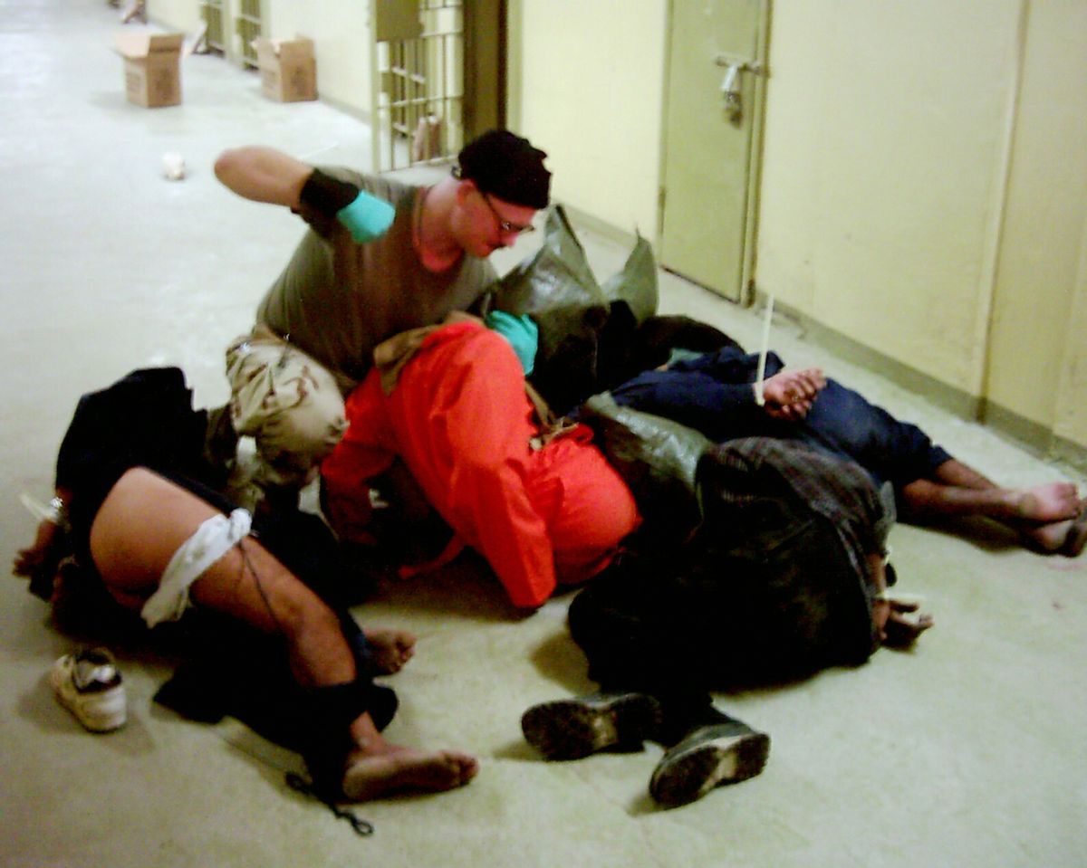 This image obtained by the Associated Press shows Cpl. Charles Graner Jr. appearing to punch one of several handcuffed detainees lying on the floor in late 2003 at the Abu Ghraib prison in Baghdad. (Associated Press)