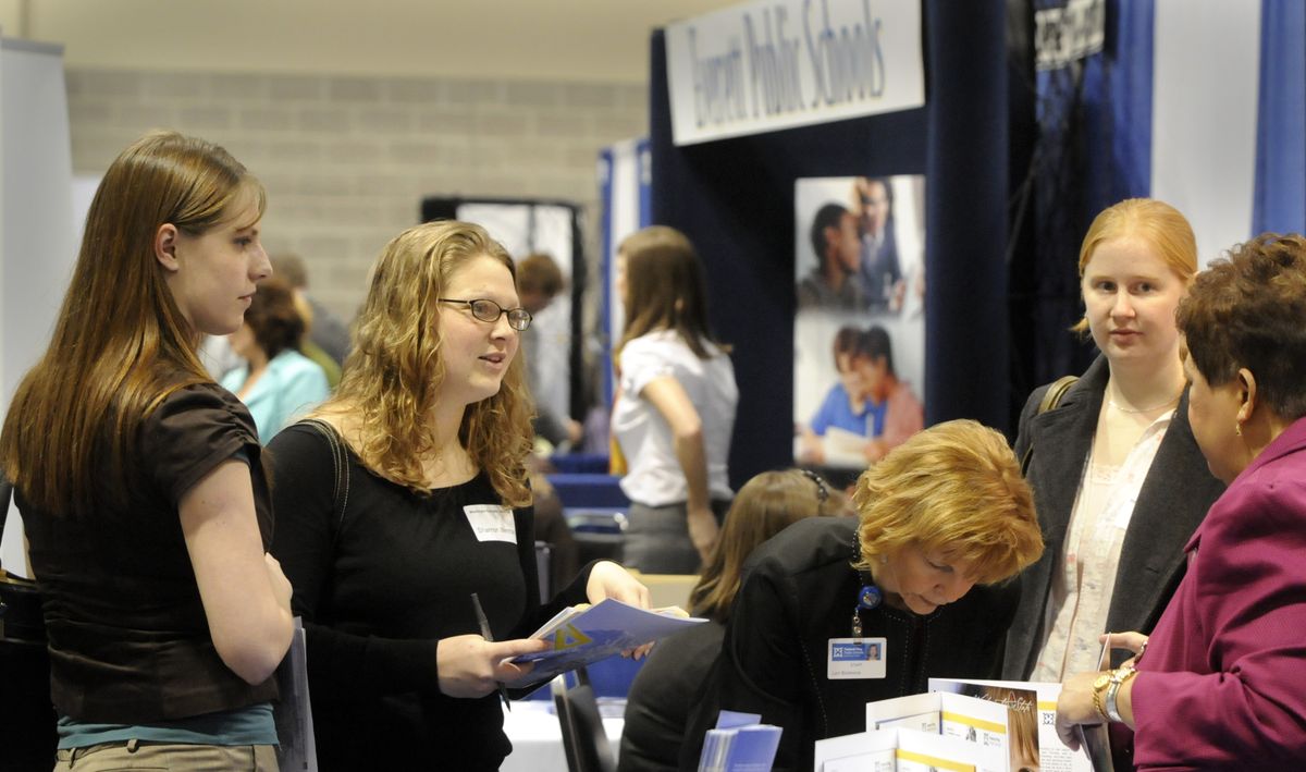 Prospective teachers Brittney Hottenstein, left, Shannon Wenman, second from left, and Tara Martin, second from right, learn about employment opportunities in Federal Way, Wash.  (Jesse Tinsley / The Spokesman-Review)