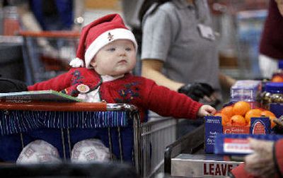 
Eight-month-old Hannah Michalek looks on as her mother's purchases are tallied at a Costco store Monday in Seattle. 
 (Associated Press / The Spokesman-Review)