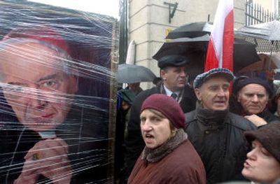 
Supporters of former Archbishop Stanislaw Wielgus shout slogans in front of the archbishop's residence in Warsaw, Poland, on Sunday. Wielgus resigned Sunday over his involvement with the communist-era secret police. At left is a portrait of the late Cardinal Stefan Wyszynski. 
 (Associated Press / The Spokesman-Review)