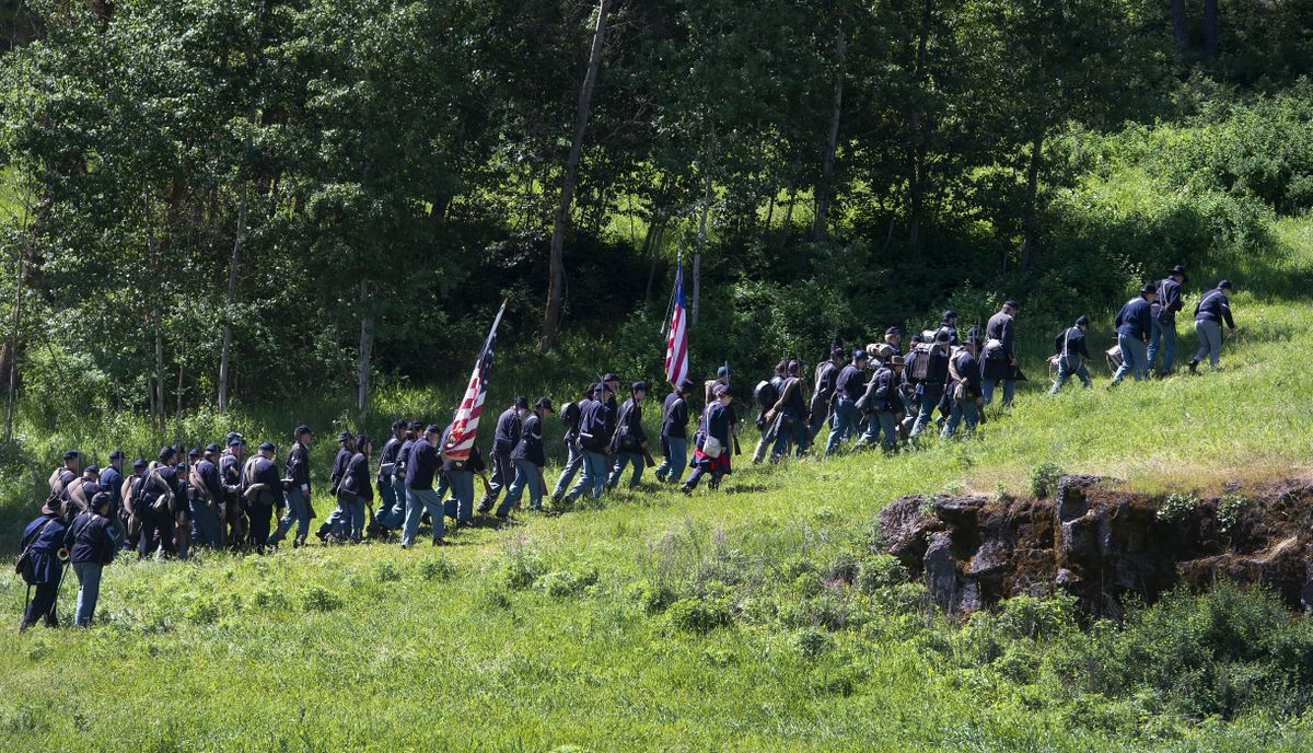 Union infantry soldiers march up to the high ground during a Washington Civil War Association re-enactment of the battle of Devil