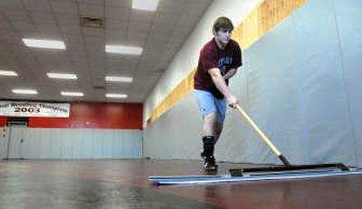 
Wrestler Evan Smit mops after putting down a mixture of hot water and bleach onto the mats at North Idaho College before wrestling practice begins Wednesday. The appearance of MRSA has made such precautions even more important in public and shared spaces. 
 (Jesse Tinsley / The Spokesman-Review)