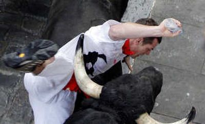 
A runner gets his T-shirt hooked by the horn of a bull Saturday on the first day of the running of the bulls during the San Fermin festival in Pamplona, Spain. Associated Press
 (Associated Press / The Spokesman-Review)