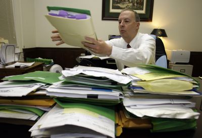 Attorney Bryan Elliott looks over bankruptcy files at his office in Hickory, N.C. In 2005, Congress imposed higher fees on those seeking bankruptcy and began to require credit counseling.   (Associated Press / The Spokesman-Review)