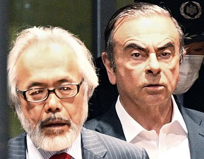 FILE - In this April 25, 2019, file photo, former Nissan Chairman Carlos Ghosn, right, walks behind his lawyer Takashi Takano as he leaves the Tokyo Detention Center in Tokyo. Takano said Saturday, Jan. 4, 2020, he felt outraged and betrayed by his client's escape from Japan to Lebanon, but also expressed an understanding for his feelings of not being able to get a fair trial. 