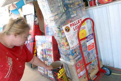 
Denise Comer points out the largest collection of fireworks sold at her husband's stand, Two Vets Fireworks, at the corner of U.S. 95 and Highway 58 near Worley on Saturday. It's called the 