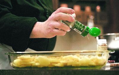 
Foucachon sprinkles ground bay leaves onto a potato dish during a French cooking class at his home. 
 (The Spokesman-Review)