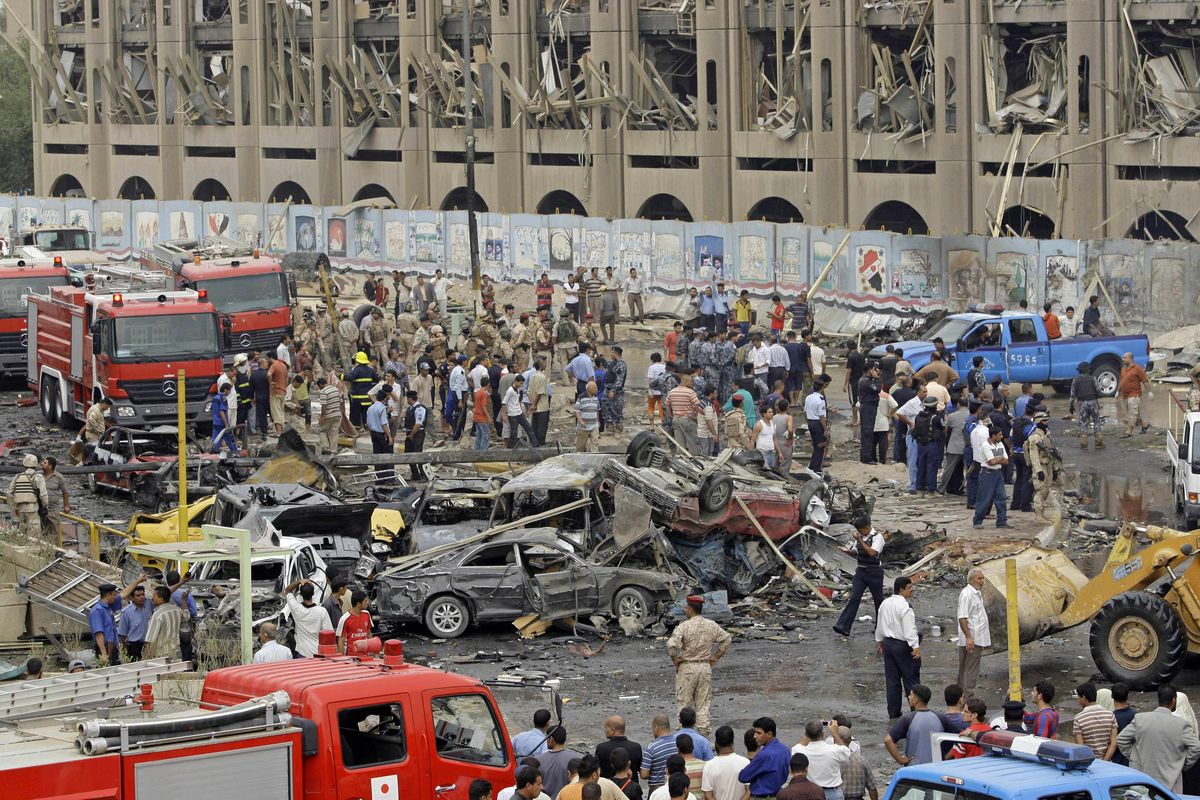 Iraqis gather at the site of a massive bomb attack at the Ministry of Justice on Sunday after a pair of powerful explosions rocked downtown Baghdad. Associated Press photos (Associated Press photos / The Spokesman-Review)