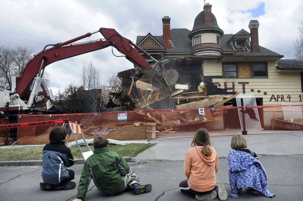 Children get a front-row seat to watch the duplex being torn down. Most of the materials from the duplex will be recycled or reused. (Dan Pelle / The Spokesman-Review)