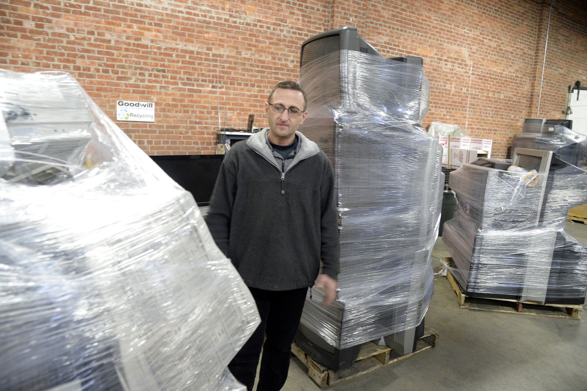 Mike Egeland, of Goodwill Industries, stands among pallets of discarded electronics Thursday at the Goodwill warehouse in Spokane Valley. (Jesse Tinsley)