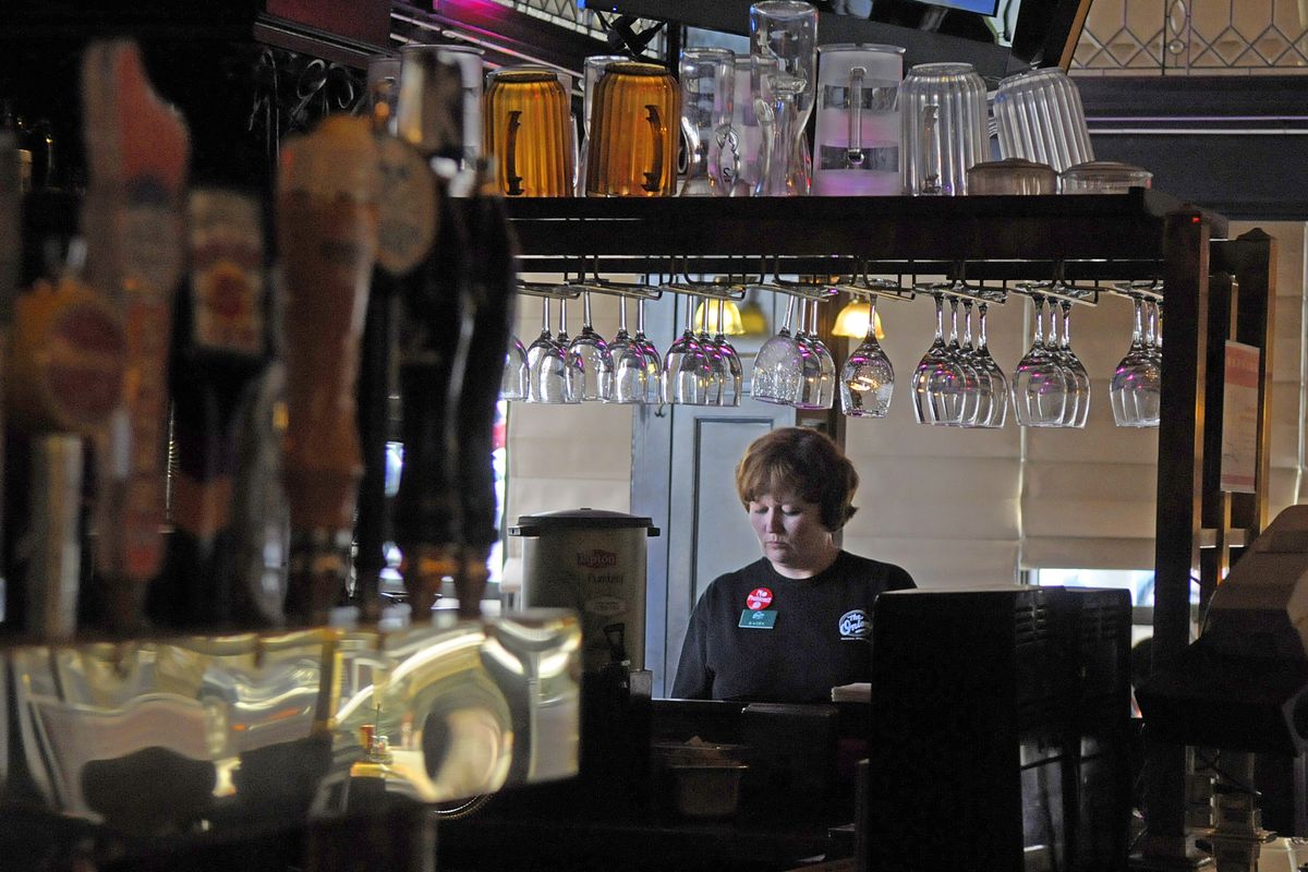 Health care reform will hit the restaurant business quickly since many dining establishments have a large number of part-time employees. Kathy Hutchinson, who usually works three shifts a week, inputs a lunch order to the kitchen for her customers at The Onion in downtown Spokane on Thursday. (CHRISTOPHER ANDERSON)