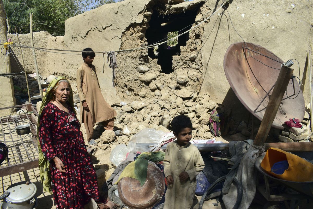 A family is seen inside their house following an earthquake in Harnai, about 60 miles east of Quetta, Pakistan, Thursday, Oct. 7, 2021. The powerful earthquake collapsed at least one coal mine and dozens of mud houses in southwest Pakistan early Thursday.  (Arshad Butt)