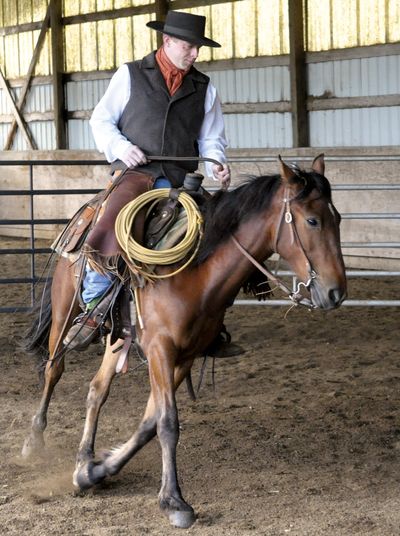 Trainer Blake Powell, of Lebanon, Ore., works with EZ, a 2-year-old mustang from eastern Oregon, on Monday. (Associated Press)