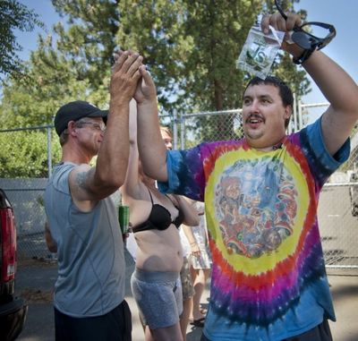 In this SR file photo from July 8, 2014, Mike Boyer races through the crowd showing off his 4 grams of pot he bought as the first in line to legally purchase marijuana at Spokane Green Leaf on Country Homes Boulevard. (Dan Pelle/SR)