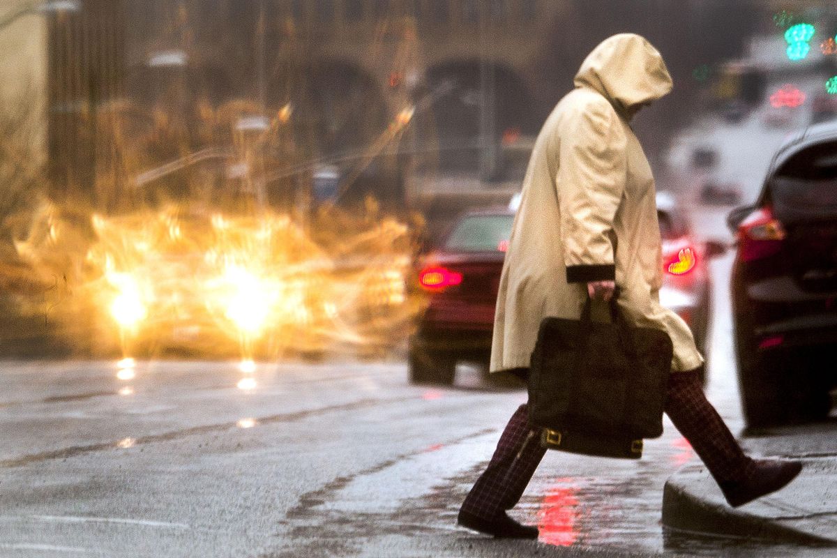 A pedestrian crosses Monroe Street during the morning rain in Spokane on Thursday, Jan. 17, 2019. (Kathy Plonka / The Spokesman-Review)