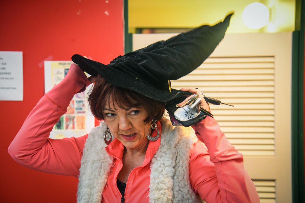 Renee Raidt tries on a hat during the Spokane Civic Theater Costume Sale, Friday, April 19, 2019. Raidt, a belly dancer, was looking for items to wear when her dance group performs a Harry Potter-themed show. (Dan Pelle / The Spokesman-Review)