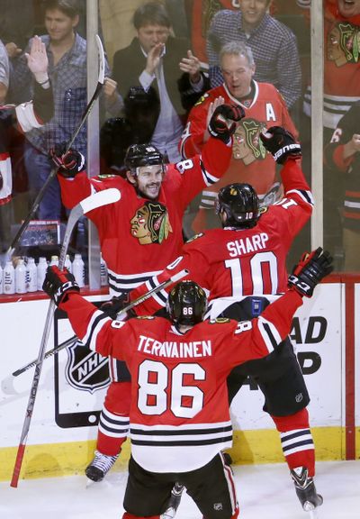 Hawks’ Antoine Vermette, top, raises arms in triumph after OT goal. (Associated Press)